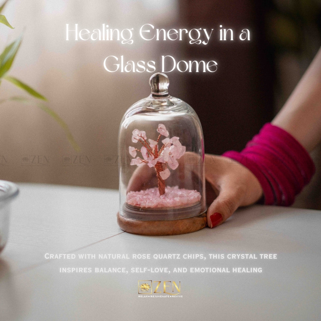 Glass dome with a crystal tree inside, held by a hand, on a light surface.