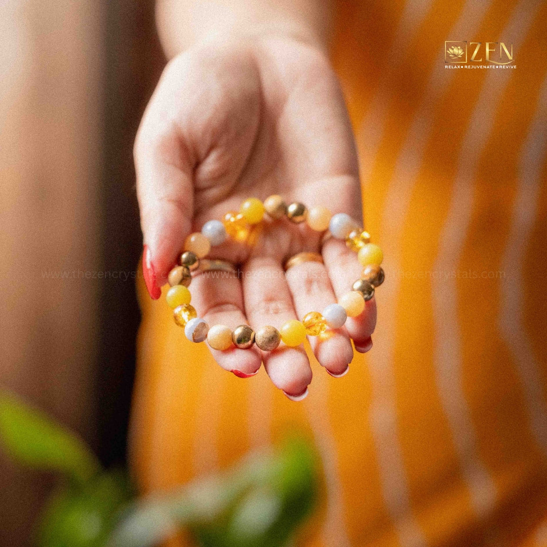 Hand holding a ruling number 3 bracelet with an orange blurred background