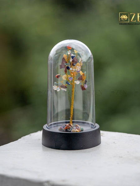 Decorative tree inside a glass dome on a blurred natural background with 'ZEN' branding.
