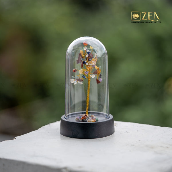 Decorative tree inside a glass dome on a blurred natural background with 'ZEN' branding.
