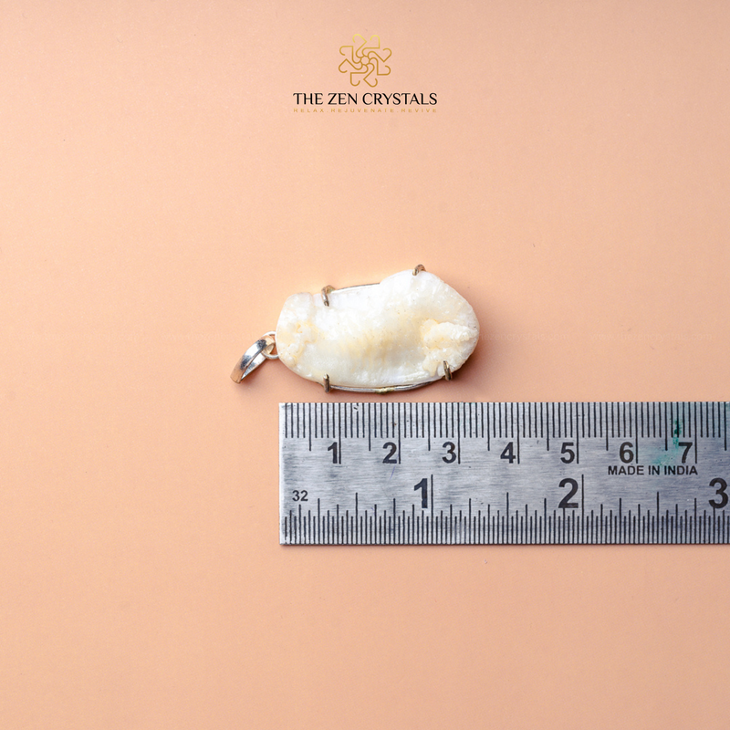 Shukra Mani pendant next to a ruler on a beige background with 'The Zen Crystals' logo.
