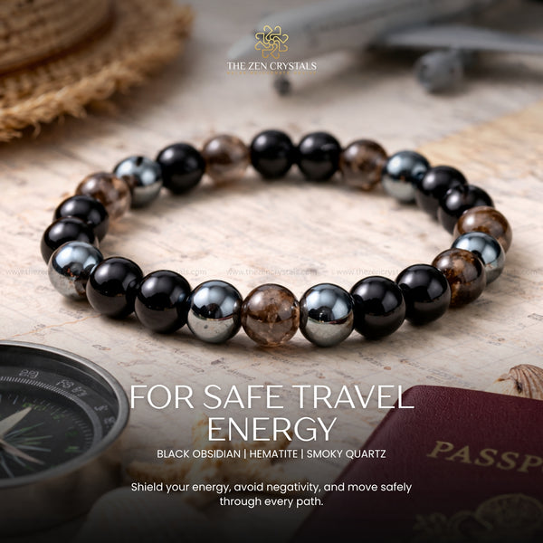 Safe Travel Energy Bracelet Black obsidian, hematite, and smoky quartz bracelet with travel-themed items on a wooden surface.