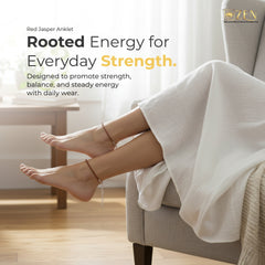 Person sitting on a couch with feet up, wearing a red Jasper Anklelet, with promotional text about energy and strength.