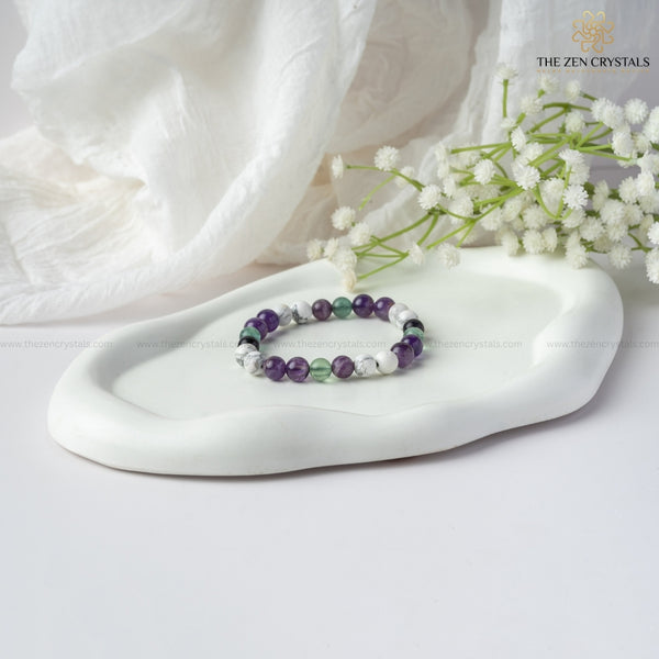 clarity of thought bracelet on a white dish with white flowers and a white cloth, branded 'The Zen Crystals'.