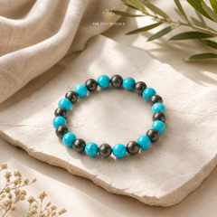 Turquoise and pyrite beaded bracelet on a stone surface with 'The Zen Crystals' branding.