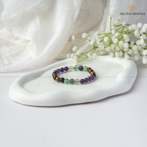 improved concentration energy bracelet on a white dish with white flowers and 'The Zen Crystals' branding.