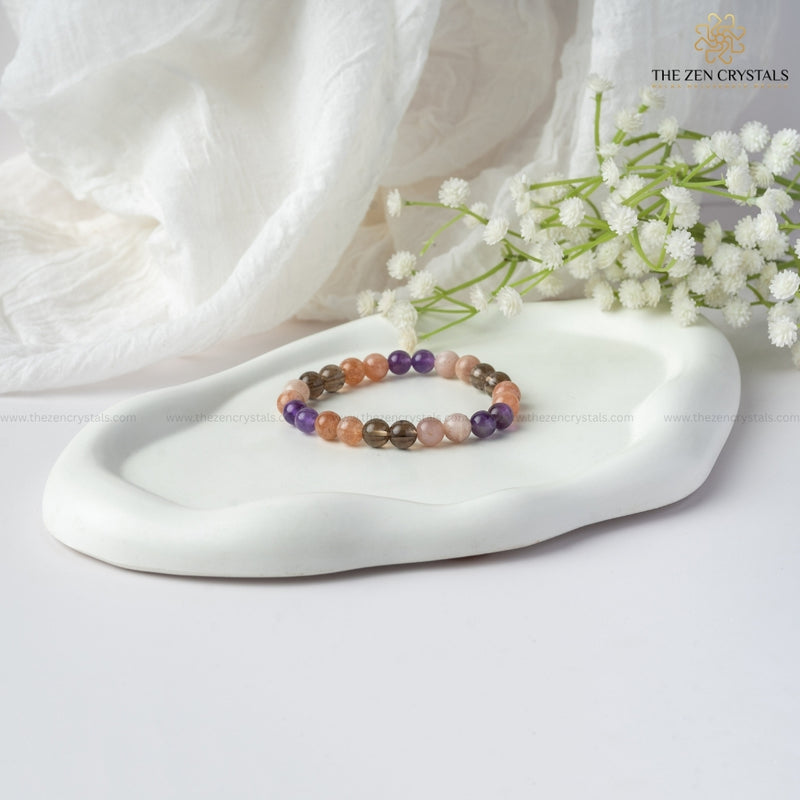 calm & peace energy bracelet on a white dish with white flowers and soft fabric in the background, branded 'The Zen Crystals'.