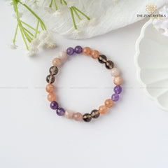 calm & peace energy bracelet on a white surface with flowers and a decorative plate in the background, branded 'The Zen Crystals'.