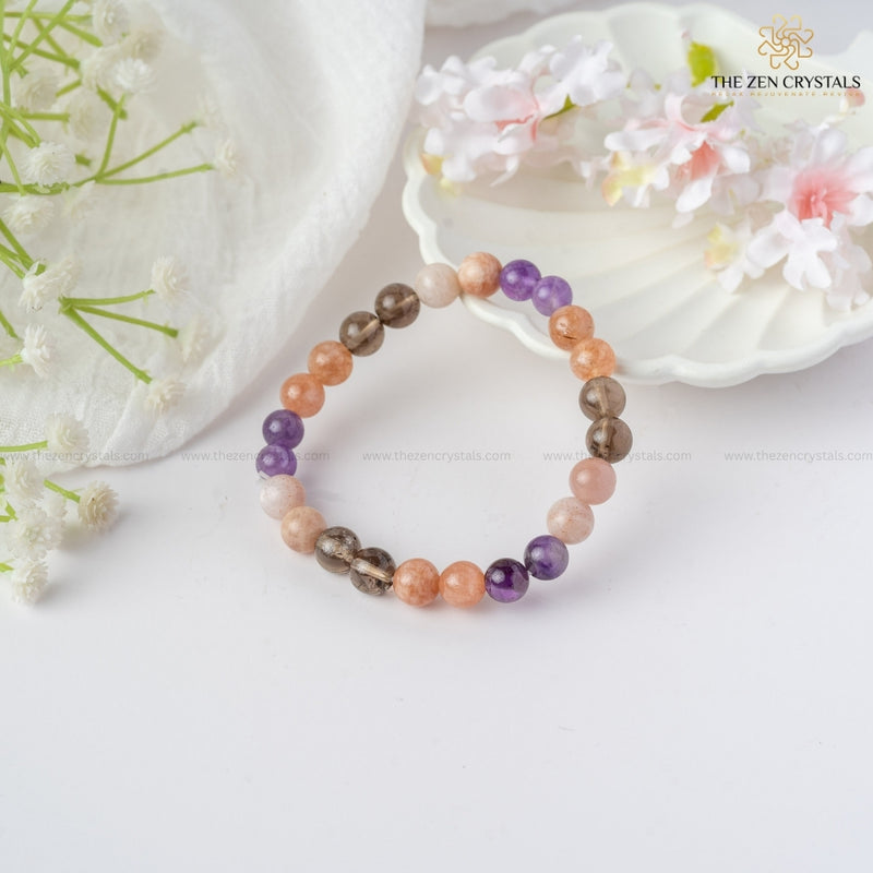 calm & peace energy bracelet on a white surface with flowers and a shell in the background, branded 'The Zen Crystals'.