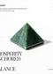 Green jade pyramid with text about its properties on a white background