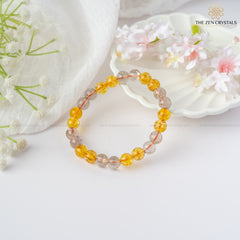 Success & Protection Energy Bracelet bracelet with yellow and clear beads on a white surface with flowers, featuring 'The Zen Crystals' brand.