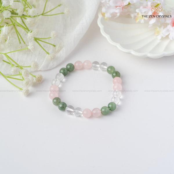 Harmony In Relationship Bracelet with green, pink, and clear beads on a white background with flowers.