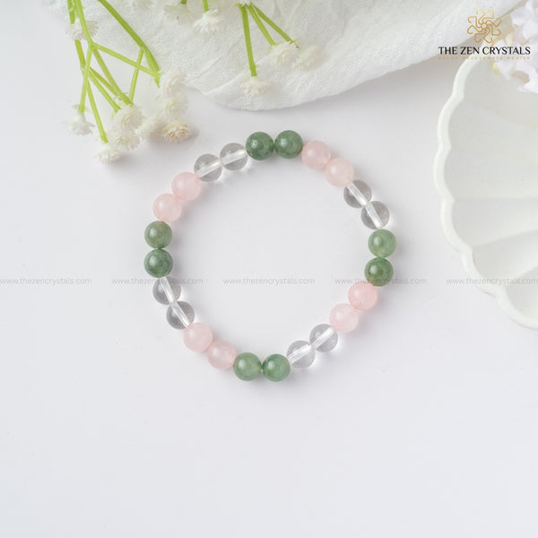 Harmony In Relationship bracelet with green, pink, and clear beads on a white background with flowers.