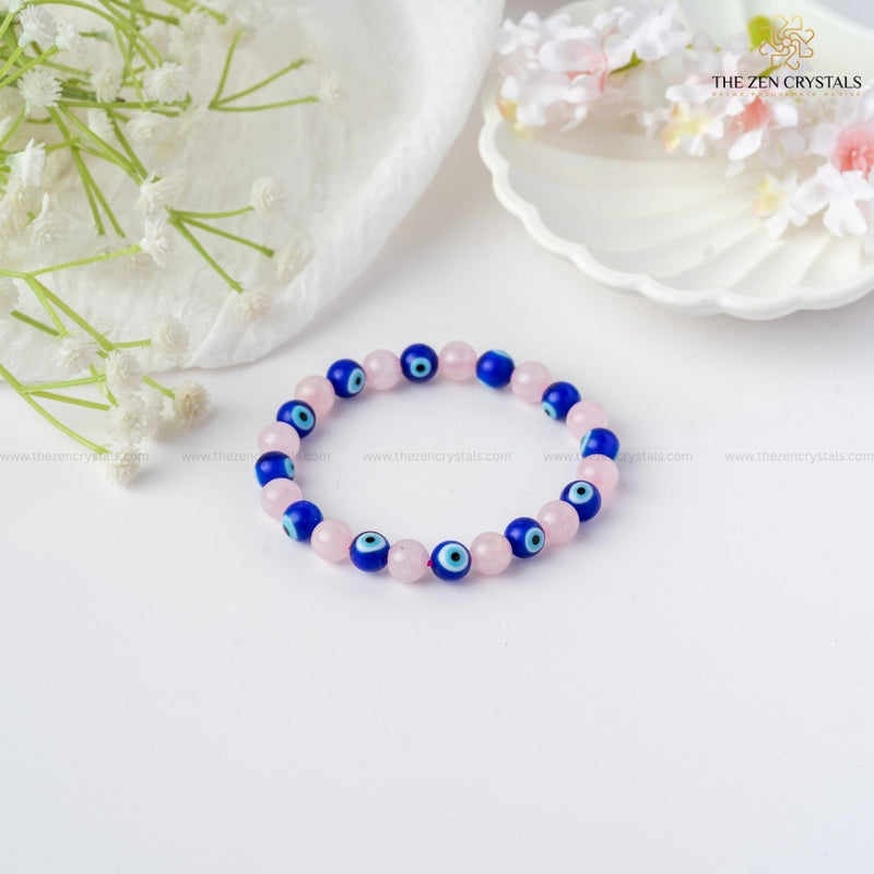Love & Protection Energy Bracelet with blue and pink beads on a white background with flowers.