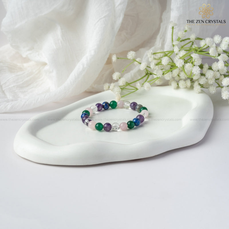 Focus & Clarity Energy In Studies Bracelet on a white dish with white flowers and a white fabric background, branded 'The Zen Crystals'.