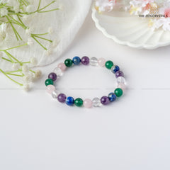 Focus & Clarity Energy In Studies Bracelet on a white surface with flowers and a shell in the background, branded 'The Zen Crystals'.