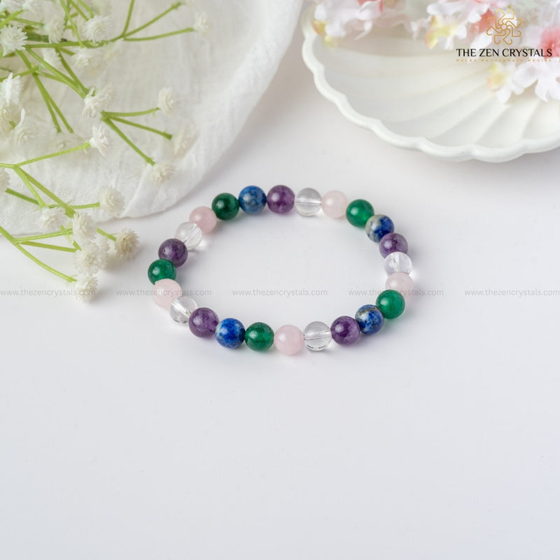 Focus & Clarity Energy In Studies Bracelet on a white surface with flowers and a shell in the background, branded 'The Zen Crystals'.