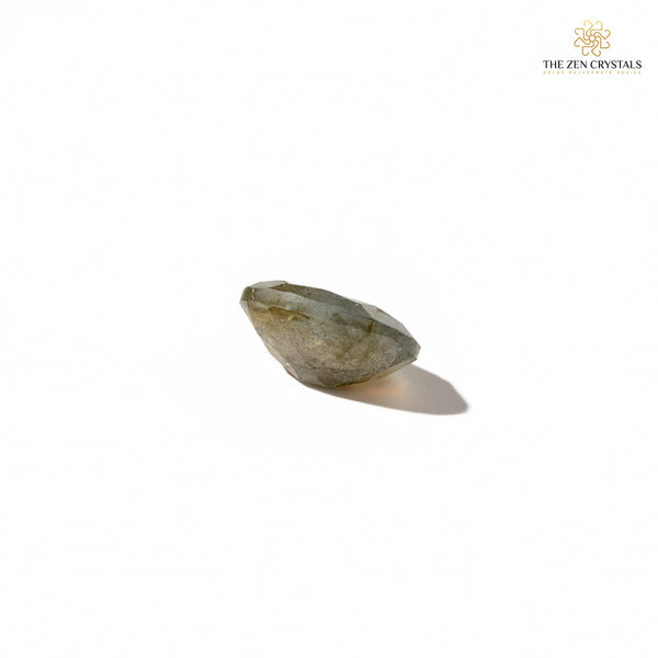 labradorite stone with a soft glow on a white background, branded 'The Zen Crystals'.