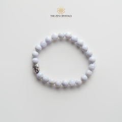 blue lace bracelet with a silver charm on a light gray background, branded 'The Zen Crystals'.