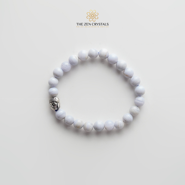 blue lace bracelet with a silver charm on a light gray background, branded 'The Zen Crystals'.