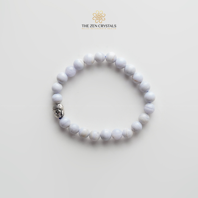 blue lace bracelet with a silver charm on a light gray background, branded 'The Zen Crystals'.
