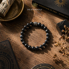 Shungite bracelet on a wooden surface with 'The Zen Crystals' branding.
