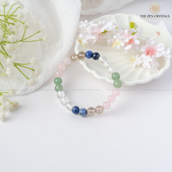 Inner Peace Energy Bracelet with multicolored beads on a white surface with flowers and a shell.