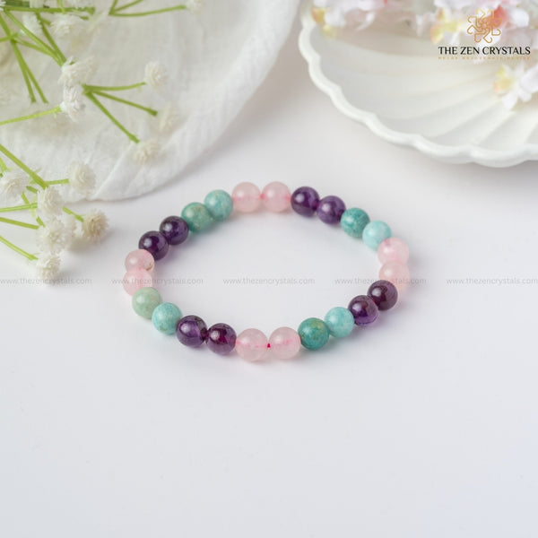 Relaxation Energy Bracelet on a white surface with flowers in the background, branded 'The Zen Crystals'.