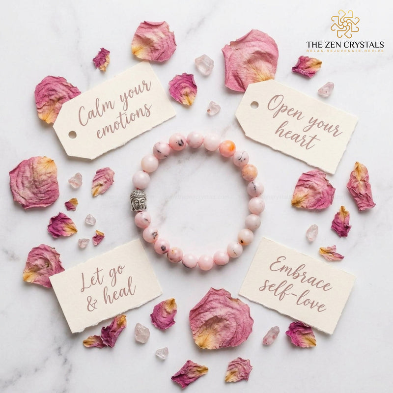 Pink opal bracelet with inspirational cards and dried flowers on a marble surface, branded 'The Zen Crystals'.