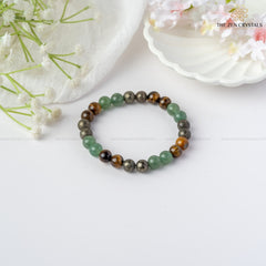 Business Success Energy Bracelet on a white surface with flowers in the background, branded 'The Zen Crystals'.