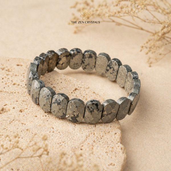 Pyrite flat bead bracelet on a stone surface with 'The Zen Crystals' branding.