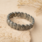 Pyrite flat bead bracelet on a stone surface with 'The Zen Crystals' branding.