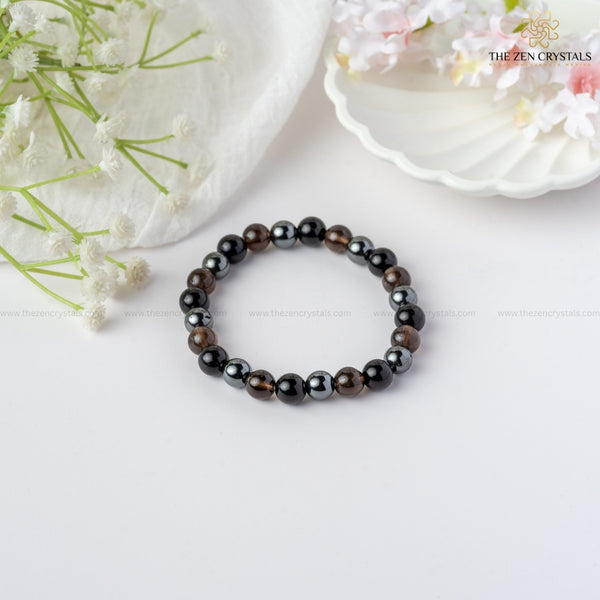 Safe Travel Energy Bracelet on a white surface with flowers in the background, branded 'The Zen Crystals'.