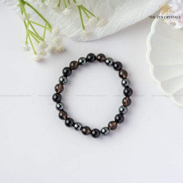 Safe Travel Energy Bracelet on a white surface with white flowers in the background