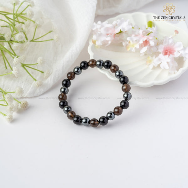 Safe Travel Energy Bracelet on a white surface with decorative flowers and shells.