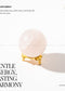 Rose Quartz Sphere with gold base on a white background, featuring text about its properties and brand 'Zen'.