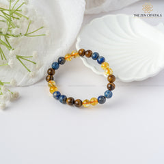 Confidence Energy Bracelet with multicolored stones on a white surface with flowers and shells.