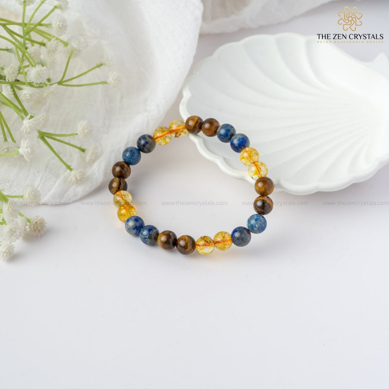 Confidence Energy Bracelet with multicolored stones on a white surface with flowers and shells.