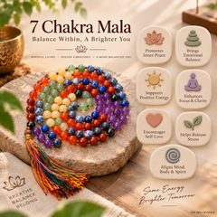 A 7 chakra mala bead bracelet with a tassel, displayed on a stone slab with promotional text and benefit tiles. The beads are arranged in rainbow order, and the background includes decorative props and a wooden surface.