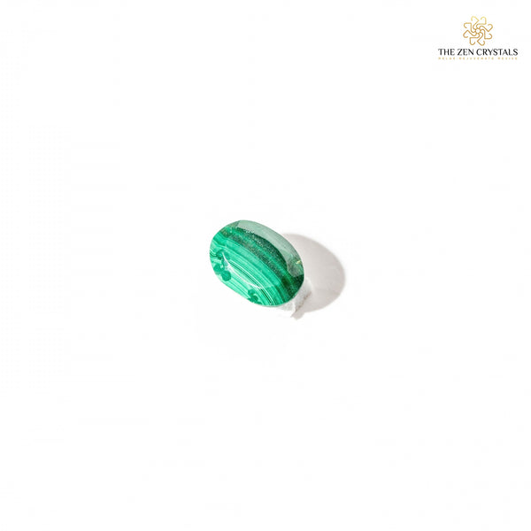 Green malachite gemstone in a white setting on a white background with 'The Zen Crystals' branding.