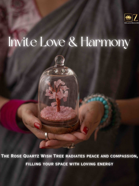 Person holding a glass dome with a rose quartz wish tree, promoting love and harmony.