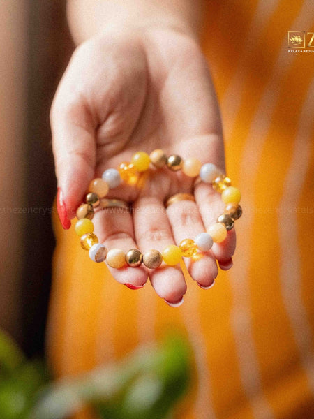 Hand holding a ruling number 3 bracelet with an orange blurred background