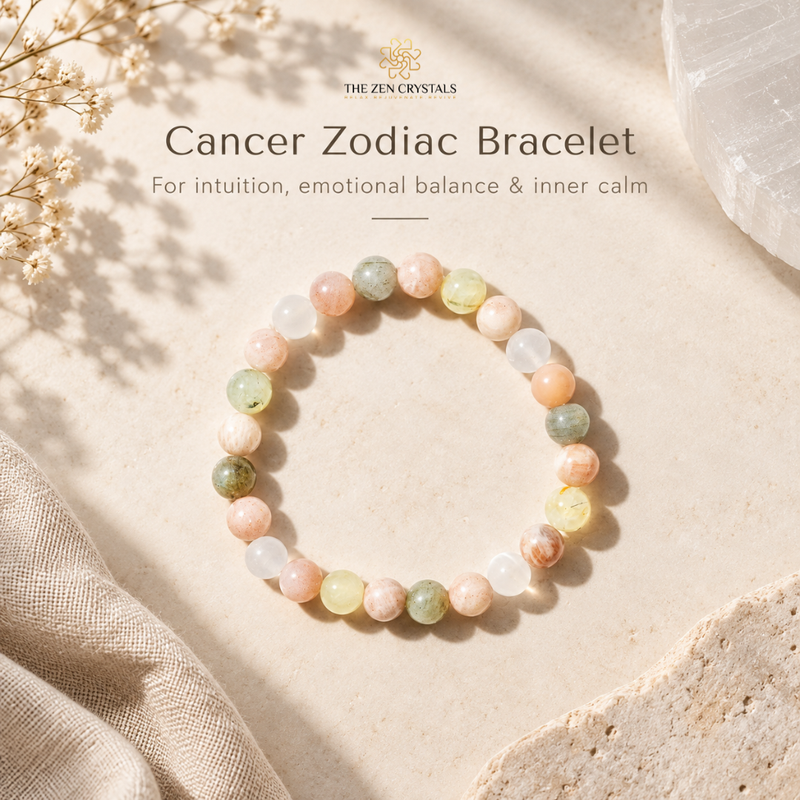 A Cancer Zodiac bracelet by The Zen Crystals made of multi-colored polished gemstone beads in soft peach, pink, green, yellow, and white tones, displayed on a textured beige surface with decorative dried flowers and a crystal cluster.