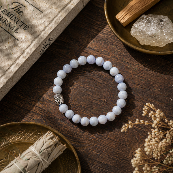 blue lace agate bracelet on a wooden surface with crystals and a book in the background