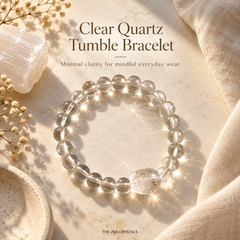 A clear quartz tumbler beaded bracelet with a larger polished clear stone, displayed on a textured beige surface with warm sunlight and shadows. The image includes text reading 'Clear Quartz Tumbler Bracelet' and the brand 'The Zen Crystals'.