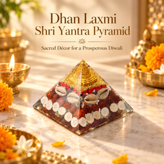 A glass pyramid Shri Yantra with a gold metallic top and layered natural materials inside, displayed on a marble surface with lit diya lamps, marigold flowers, and decorative brass vessels in a warm Diwali setting. Text at the top reads 'Dhan Laxmi Shri Yantra Pyramid' and 'Sacred Decor for a Prosperous Diwali'.