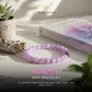 Kunzite bracelet on a wooden surface with a book and plant, branded by The Zen Crystals.