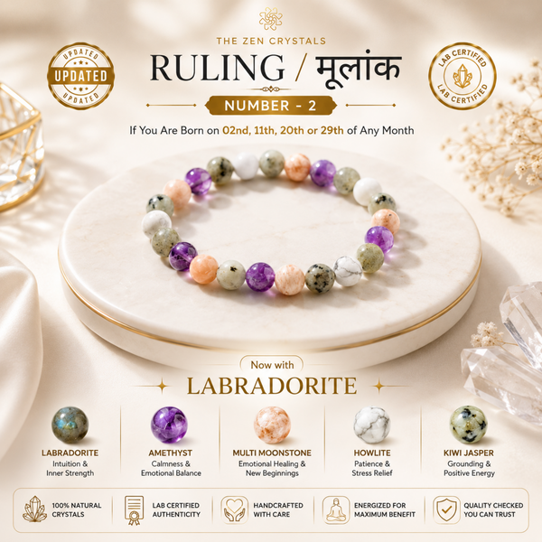 RULING NUMBER 2 BRACELET arranged in a circle on a white marble tray, with decorative crystals and soft neutral background elements. Text at the top reads 'THE ZEN CRYSTALS RULING / मूलनाक NUMBER - 2' and the bottom section lists crystal benefits including labradorite, amethyst, multi moonstone, howlite, and kiwi jasper.