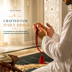 A person in a white robe holds red beaded prayer beads with a tassel in a softly lit interior. The left side includes promotional text reading 'THE ZEN CRYSTALS' and 'CRAFTED FOR DAILY DHIKR' with a short descriptive subtitle.