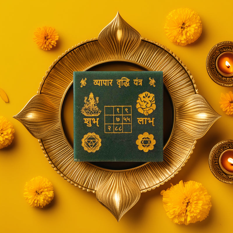 Green jade vyapar vridhi yantra on a decorative yellow background with flowers and candles.